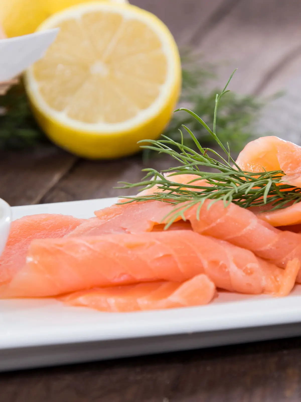 Portion of fresh Salmon with herbs on wooden background