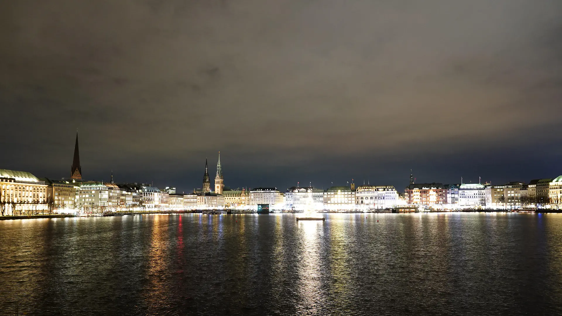 24.11.2021, Hamburg: Die Alstertanne leuchtet auf der Binnenalster. Im Hintergrund ist das Rathaus zu sehen. ist der Michel Foto: Marcus Brandt/dpa +++ dpa-Bildfunk +++