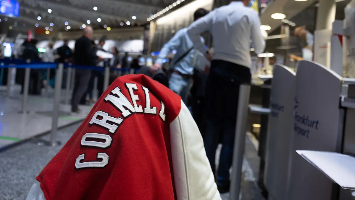 08.11.2021, Hessen, Frankfurt/Main: Eine Jacke mit dem Schriftzug der Universität Cornell aus dem US-Bundesstaat New York hängt auf einem Koffer, der auf dem Flughafen Frankfurt, am Check-In von Singapore Airlines für einen Flug nach New York. Ab dem 8. November sind Flüge mit geimpften EU-Bürgern in die USA wieder erlaubt. Foto: Sebastian Gollnow/dpa +++ dpa-Bildfunk +++
