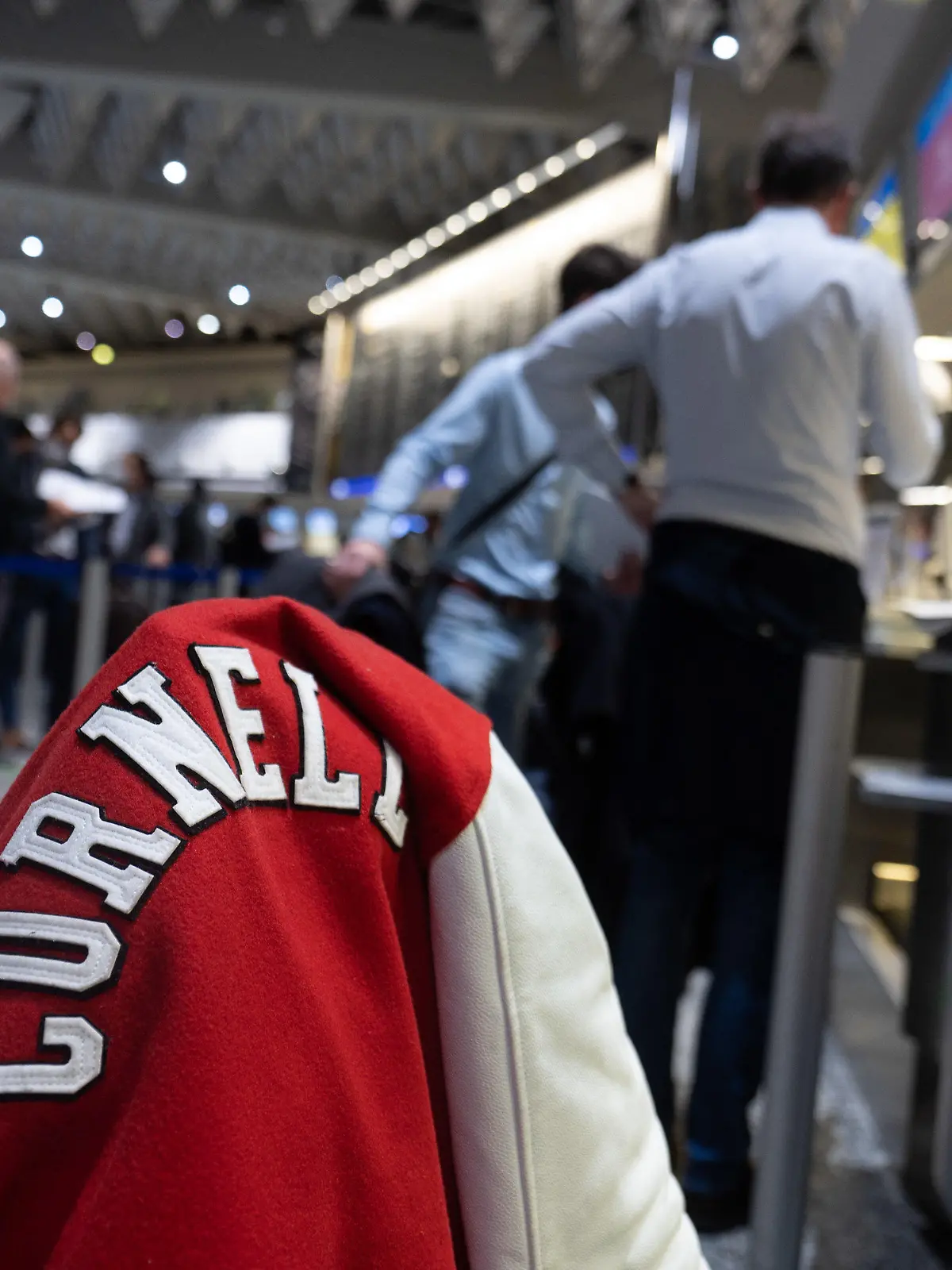 08.11.2021, Hessen, Frankfurt/Main: Eine Jacke mit dem Schriftzug der Universität Cornell aus dem US-Bundesstaat New York hängt auf einem Koffer, der auf dem Flughafen Frankfurt, am Check-In von Singapore Airlines für einen Flug nach New York. Ab dem 8. November sind Flüge mit geimpften EU-Bürgern in die USA wieder erlaubt. Foto: Sebastian Gollnow/dpa +++ dpa-Bildfunk +++