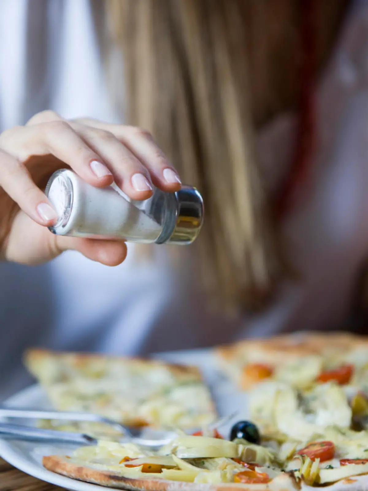 Woman salting pizza, selected focus, canon 1Ds mark3