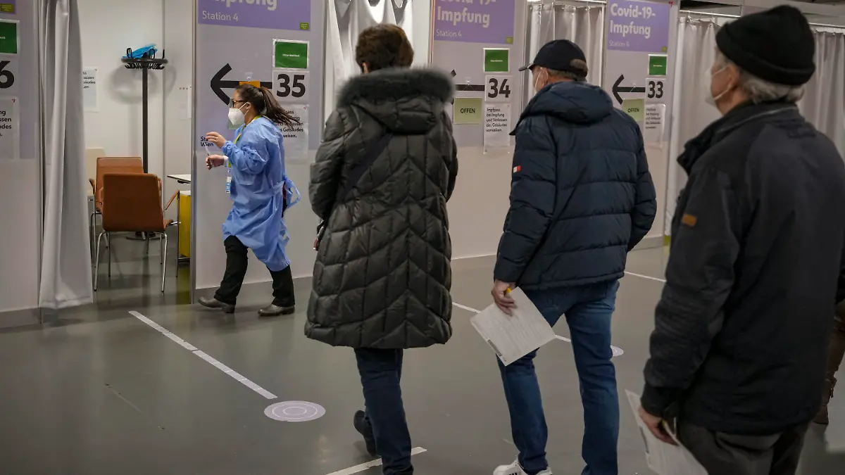 22.11.2021, Österreich, Wien: Menschen warten auf ihre Corona-Impfung. Seit dem 22.11.2021 befindet sich Österreich in einem vierten Lockdown. Es sind nur noch Geschäfte des täglichen Bedarfs geöffnet, der Kulturbetrieb ruht, die Museen und Kinos haben geschlossen. Foto: Vadim Ghirda/AP/dpa +++ dpa-Bildfunk +++