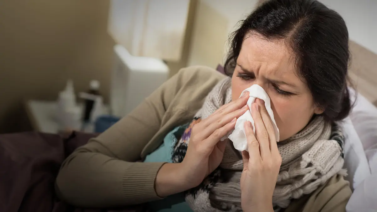 Caucasian woman having bad cold blowing her nose