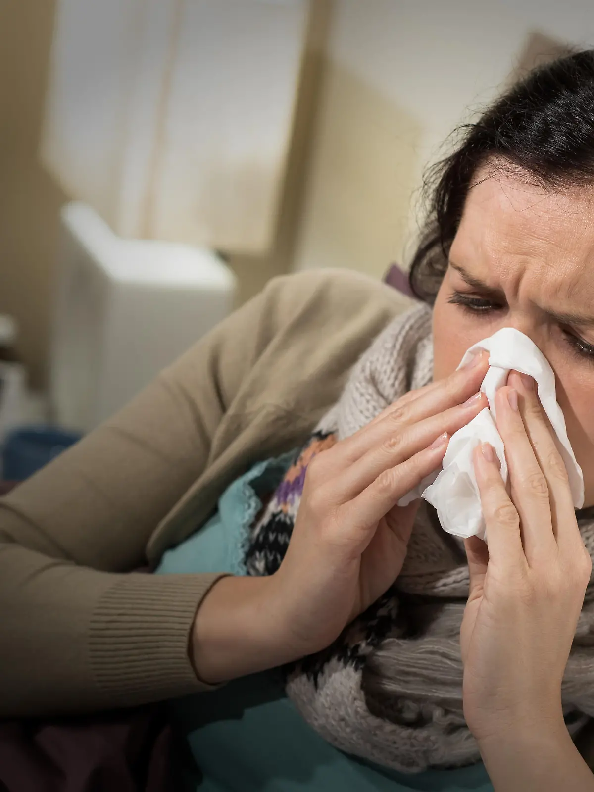 Caucasian woman having bad cold blowing her nose