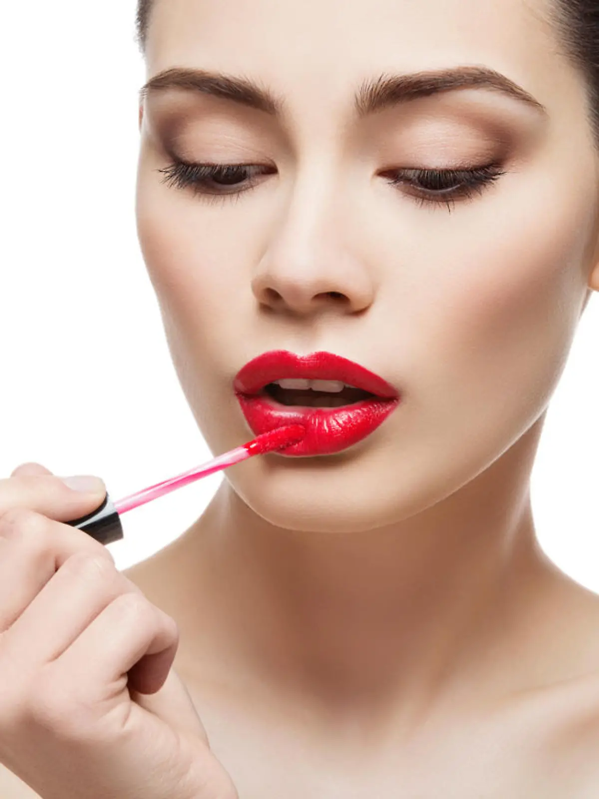 Beautiful young woman applying red lipgloss with applicator. Isolated over white background. Copy space.