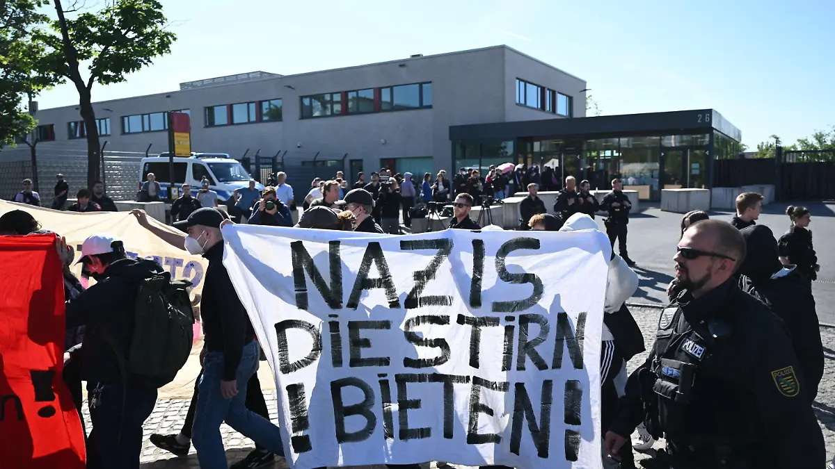 31.05.2023, Sachsen, Dresden: Demonstranten aus dem linken Spektrum laufen vor Beginn der Urteilsverkündung gegen Lina E. und drei Männer vor dem Oberlandesgericht (OLG) Dresden mit einem Banner ·Nazis die Stirn bieten· entlang. Die Gruppe aus der linksextremistischen Leipziger Szene ist wegen Mitgliedschaft in einer kriminellen Vereinigung angeklagt. Foto: Robert Michael/dpa +++ dpa-Bildfunk +++