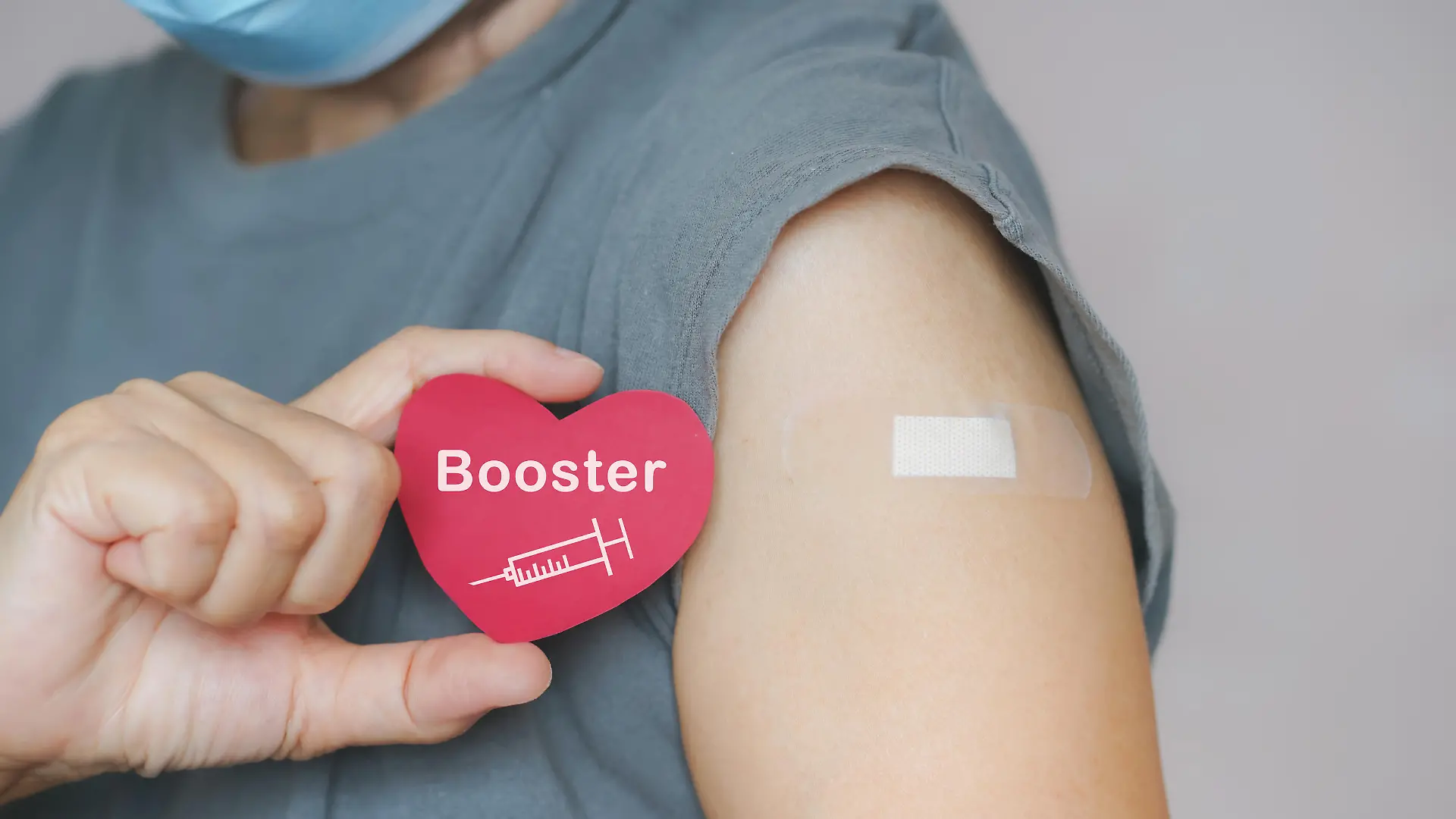 senior woman show red heart shape with syringe icon, after vaccinated or inoculation booster dose due to spread of corona virus, population, social or herd immunity concept