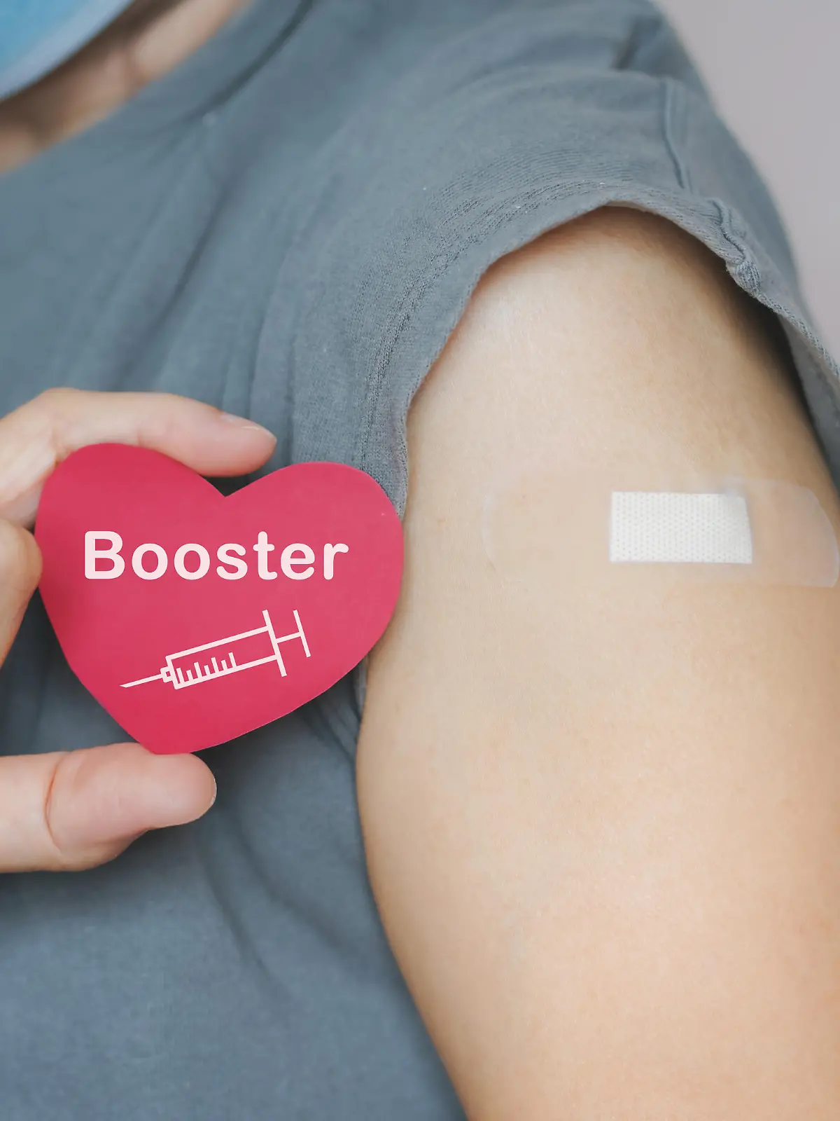 senior woman show red heart shape with syringe icon,  after vaccinated or inoculation  booster dose  due to spread of corona virus, population, social or herd immunity concept