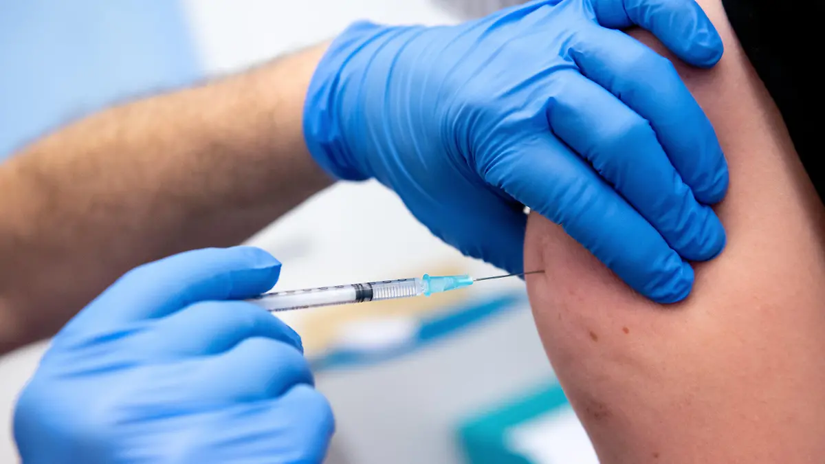 ARCHIV - 30.12.2020, Bayern, Gauting: Ein Mitarbeiter der Asklepios Klinik wird von einem Kollegen mit dem Corona-Impfstoff von Biontech/Pfizer geimpft. (zu dpa «Klinik-Chef: Impfpflicht für Personal bitter - «Politikversagen»») Foto: Sven Hoppe/dpa +++ dpa-Bildfunk +++