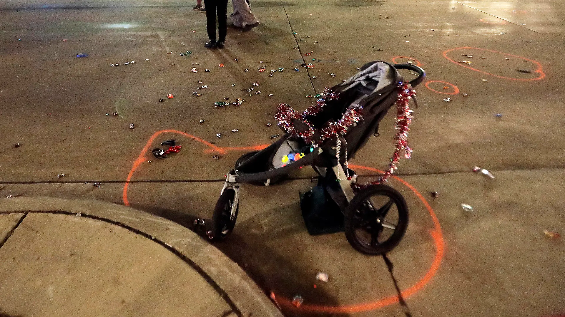 A broken children's stroller lays on W. Main St. in downtown Waukesha, Wis., after an SUV drove into a parade of Christmas marchers Sunday, Nov. 21, 2021. (John Hart/Wisconsin State Journal via AP)