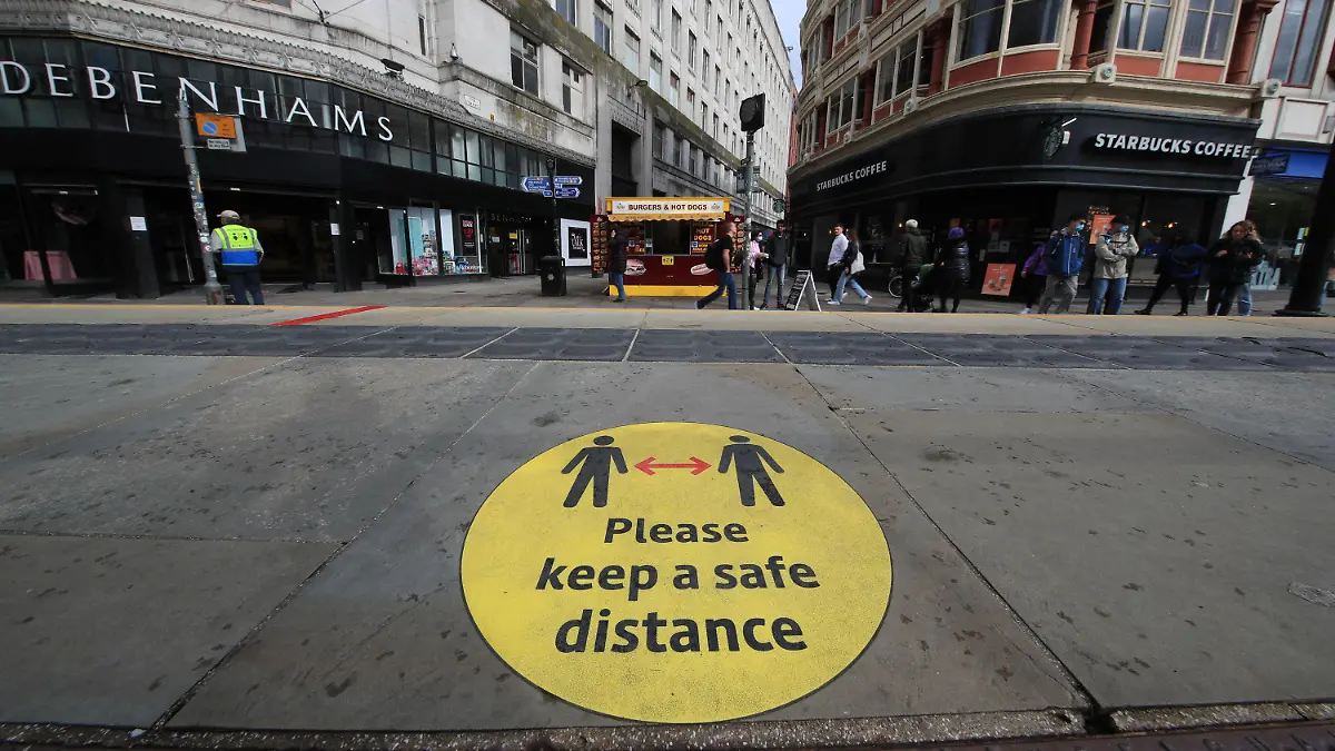 ARCHIV - 09.10.2020, Großbritannien, Manchester: Ein Leitschild auf dem Bürgersteig weist auf Beachtung der Social-Distancing-Maßnahmen hin. Britische Forscher empfehlen auf Grundlage einer neuen Studie, auch bei hohen Impfquoten Corona-Regeln beizubehalten. (zu dpa "Forscher: Corona-Maßnahmen auch bei hohen Impfquoten notwendig") Foto: Danny Lawson/PA Wire/dpa +++ dpa-Bildfunk +++