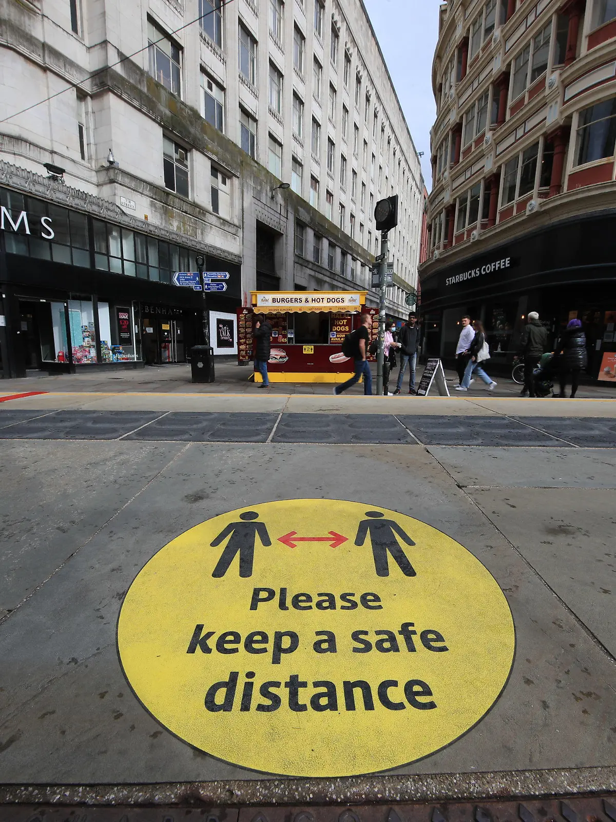 ARCHIV - 09.10.2020, Großbritannien, Manchester: Ein Leitschild auf dem Bürgersteig weist auf Beachtung der Social-Distancing-Maßnahmen hin. Britische Forscher empfehlen auf Grundlage einer neuen Studie, auch bei hohen Impfquoten Corona-Regeln beizubehalten. (zu dpa "Forscher: Corona-Maßnahmen auch bei hohen Impfquoten notwendig") Foto: Danny Lawson/PA Wire/dpa +++ dpa-Bildfunk +++