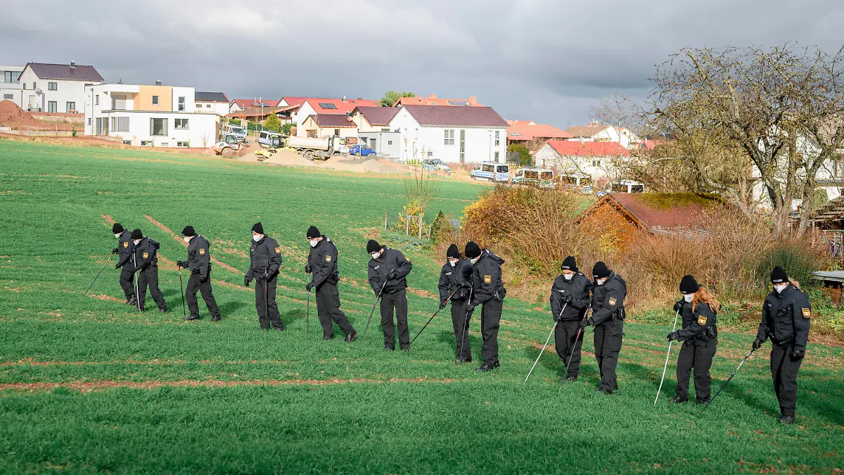 22.11.2021, Bayern, Bad Neustadt An Der Saale: Eine Einheit der Bereitschaftspolizei durchsucht das Feld rund um den Tatort nach Spuren. Ein toter Radfahrer wurde heute Morgen neben dem Radweg entdeckt. Die Polizei geht von einem Verbrechen aus. Foto: Daniel Vogl/dpa +++ dpa-Bildfunk +++