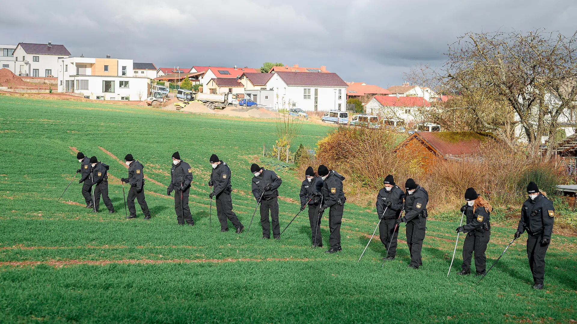 22.11.2021, Bayern, Bad Neustadt An Der Saale: Eine Einheit der Bereitschaftspolizei durchsucht das Feld rund um den Tatort nach Spuren. Ein toter Radfahrer wurde heute Morgen neben dem Radweg entdeckt. Die Polizei geht von einem Verbrechen aus. Foto: Daniel Vogl/dpa +++ dpa-Bildfunk +++