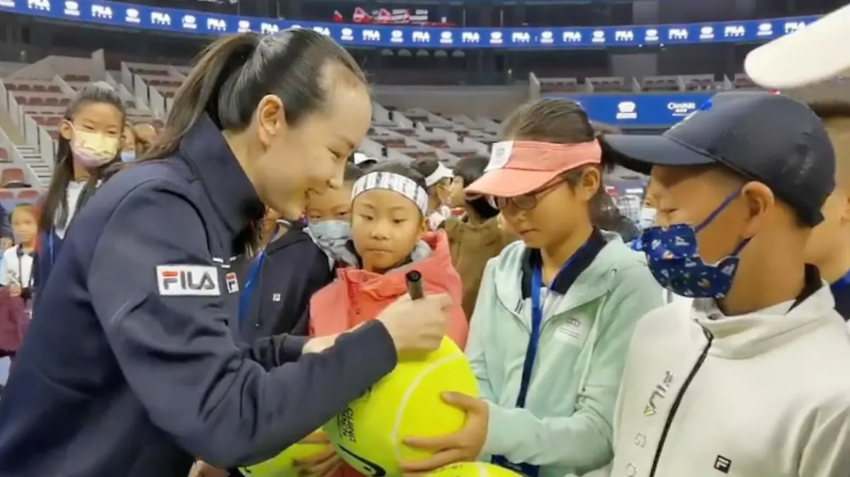 Chinese tennis player Peng Shuai signs large-sized tennis balls at the opening ceremony of Fila Kids Junior Tennis Challenger Final in Beijing, China November 21, 2021, in this screen grab obtained from a social media video. TWITTER @QINGQINGPARIS via REUTERS THIS IMAGE HAS BEEN SUPPLIED BY A THIRD PARTY. MANDATORY CREDIT. NO RESALES. NO ARCHIVES.