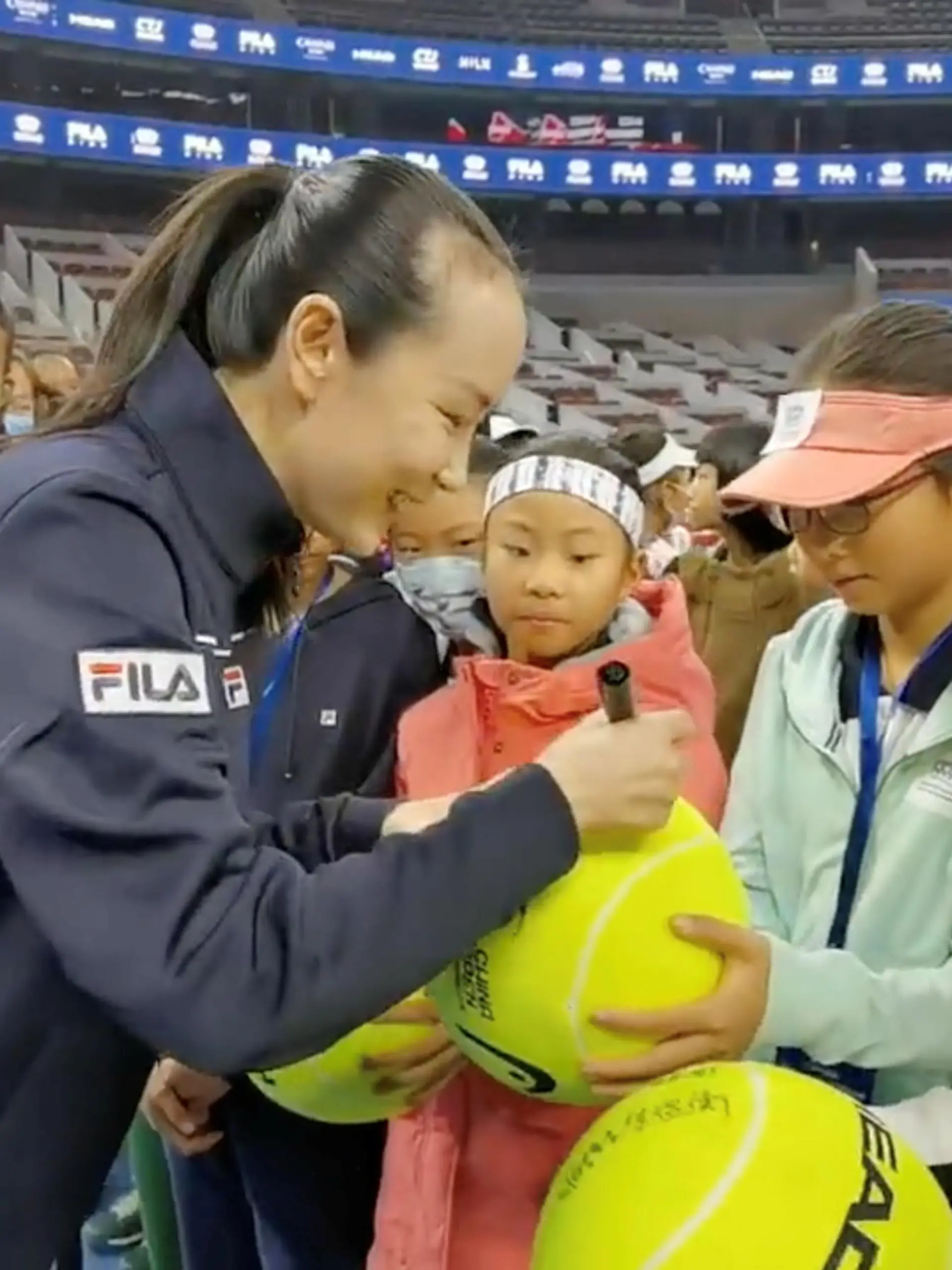 Chinese tennis player Peng Shuai signs large-sized tennis balls at the opening ceremony of Fila Kids Junior Tennis Challenger Final in Beijing, China November 21, 2021, in this screen grab obtained from a social media video. TWITTER @QINGQINGPARIS via REUTERS THIS IMAGE HAS BEEN SUPPLIED BY A THIRD PARTY. MANDATORY CREDIT. NO RESALES. NO ARCHIVES.