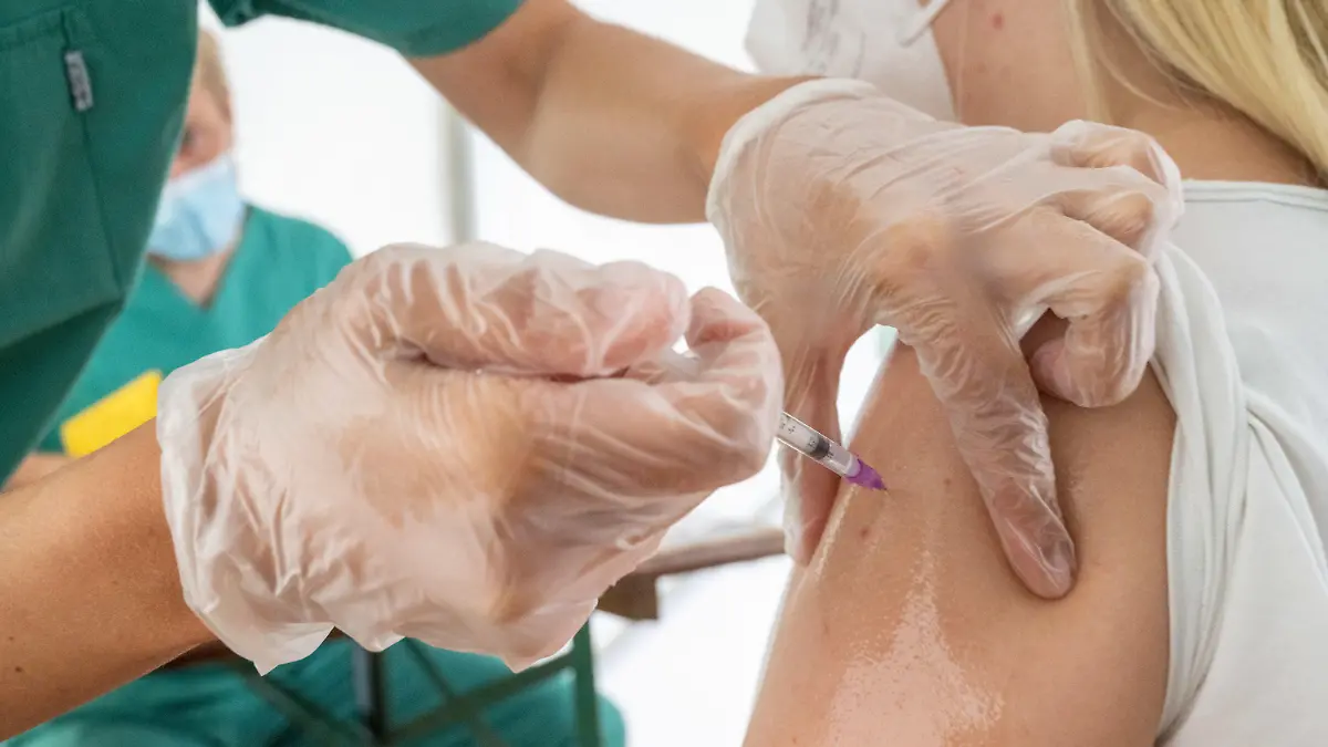 ARCHIV - 02.08.2021, Mecklenburg-Vorpommern, Lubmin: Eine junge Frau lässt sich von einer medizinischen Mitarbeiterin in einem Zelt der Gemeinde gegen das Coronavirus impfen. (zu dpa "Die Infektionen steigen rasch - wie viel Impfen geht noch?") Foto: Stefan Sauer/dpa +++ dpa-Bildfunk +++