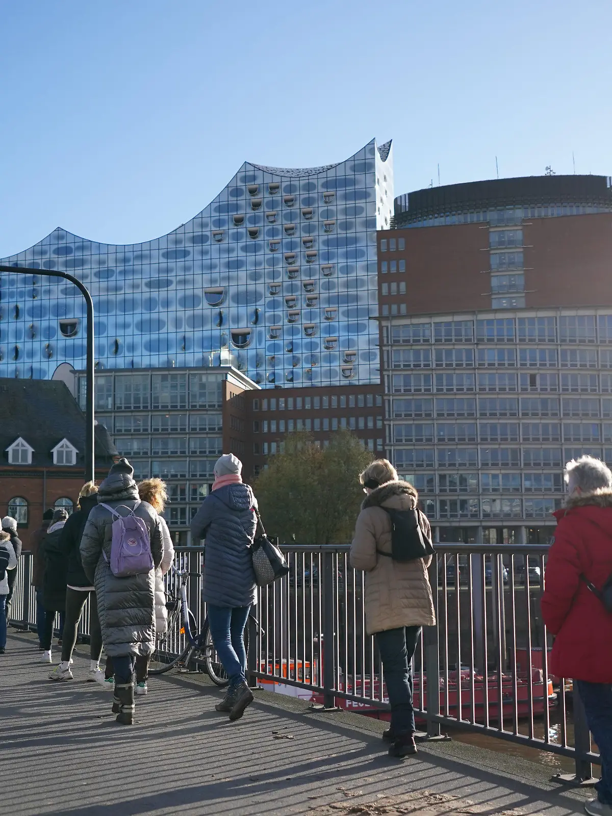 22.11.2021, Hamburg: Unzählige Menschen stehen in einer mehreren hundert Meter langen Schlange zur Impfaktion in der Elbphilharmonie an. Von der Elbphilharmonie bis fast zu den Landungsbrücken stehen die Menschen für die Impfung an. Neben Drittimpfungen werden auch Erst- und Zweitimpfungen angeboten. Verwendet werden bei der Aktion in Zusammenarbeit mit der Hamburger Sozialbehörde die Impfstoffe von Biontech, Moderna und Johnson & Johnson. Foto: Marcus Brandt/dpa +++ dpa-Bildfunk +++