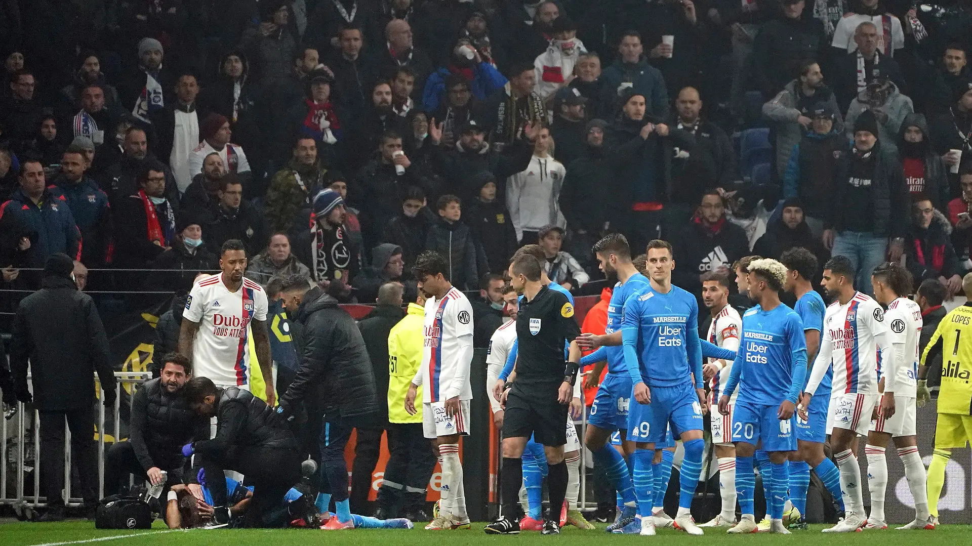 21.11.2021, Frankreich, Decines: Fußball: Ligue 1, Frankreich, Olympique Lyon - Olympique Marseille; 14. Spieltag im Groupama Stadion: Marseilles Das medizinische Personal von Marseille kümmert sich um Dimitri Payet, nachdem der von einer vollen Wasserflasche verletzt wurde, die von einem Lyoner Fan geworfen wurde. Foto: Laurent Cipriani/AP/dpa +++ dpa-Bildfunk +++