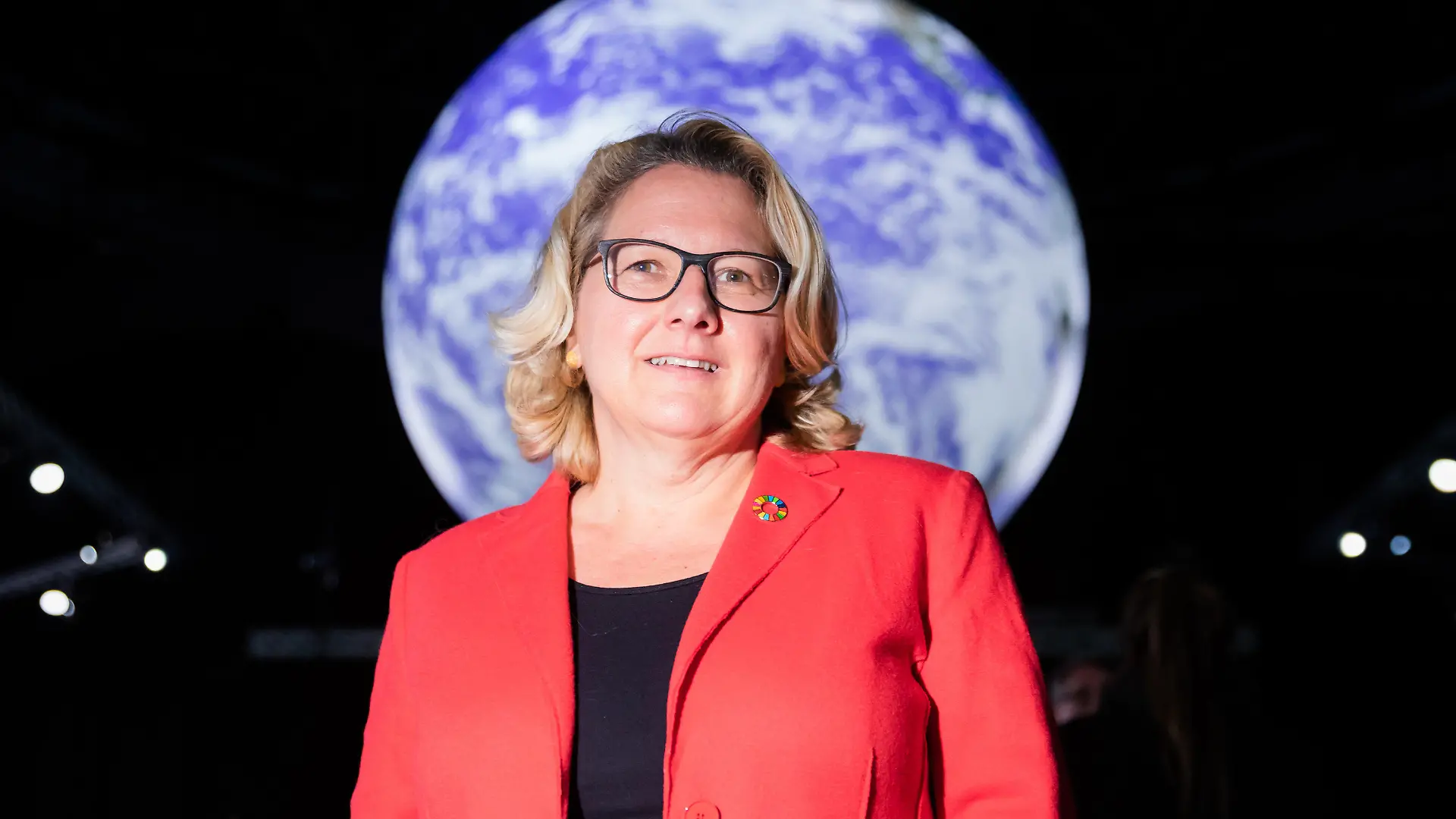 11.11.2021, Großbritannien, Glasgow: Svenja Schulze (SPD), geschäftsführende Bundesministerin für Umwelt, Naturschutz und nukleare Sicherheit, steht bei der UN-Klimakonferenz COP26 vor einem Globus.  In Glasgow findet die Weltklimakonferenz statt. Rund 200 Staaten verhandeln darüber, wie die globale Klimakrise und die Erderwärmung eingedämmt werden sollen. Foto: Christoph Soeder/dpa +++ dpa-Bildfunk +++