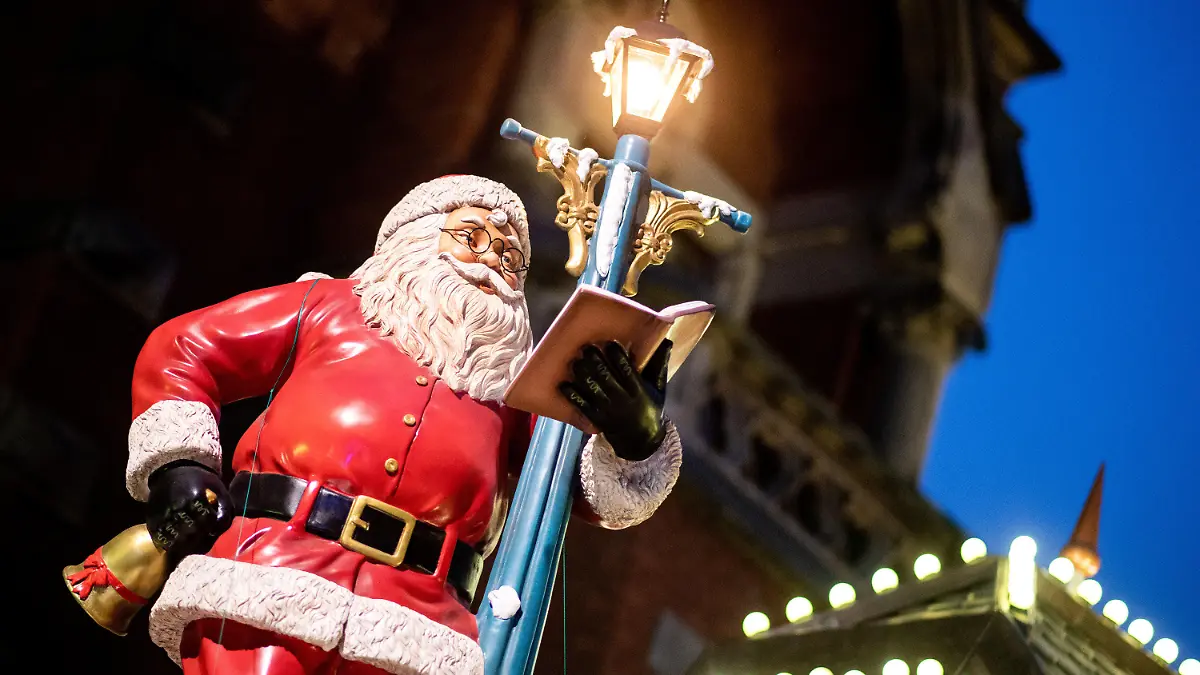 16.11.2021, Niedersachsen, Oldenburg: Eine Weihnachtsmann an einer Laterne steht als Dekoration auf einem Marktstand auf dem Lamberti-Markt in der Innenstadt. Der Weihnachtsmarkt in der Innenstadt wird am 16.11.2021 eröffnet, es gilt eine 3G-Pflicht. Auf dem Oldenburger Lamberti-Markt kommen deshalb Bändchen zum Einsatz, die die Gäste berechtigen, Speisen und Getränke zu kaufen. Foto: Hauke-Christian Dittrich/dpa +++ dpa-Bildfunk +++