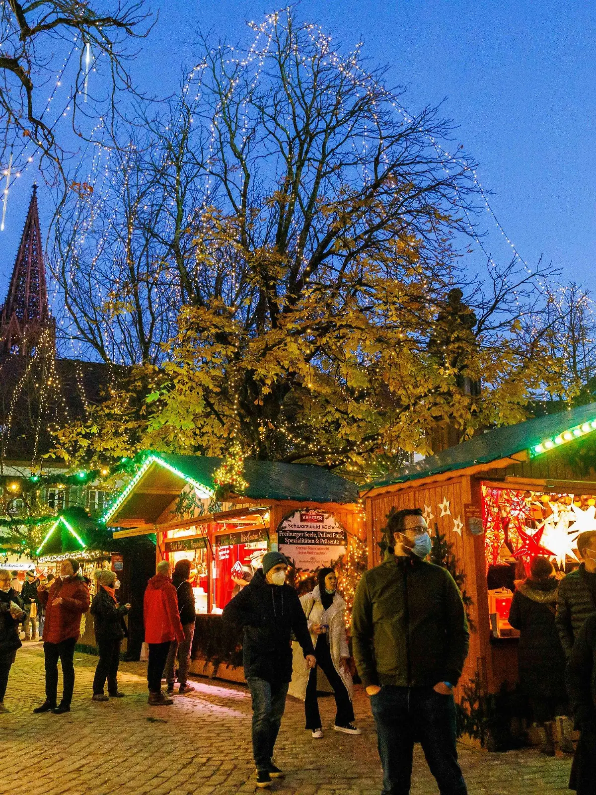 18.11.2021, Baden-Württemberg, Freiburg: Menschen stehen vor Verkaufsständen auf dem Freiburger Weihnachtsmarkt. Der Freiburger Weihnachtsmarkt wurde heute eröffnet und dauert bis zum 23. Dezember an. Foto: Philipp von Ditfurth/dpa +++ dpa-Bildfunk +++