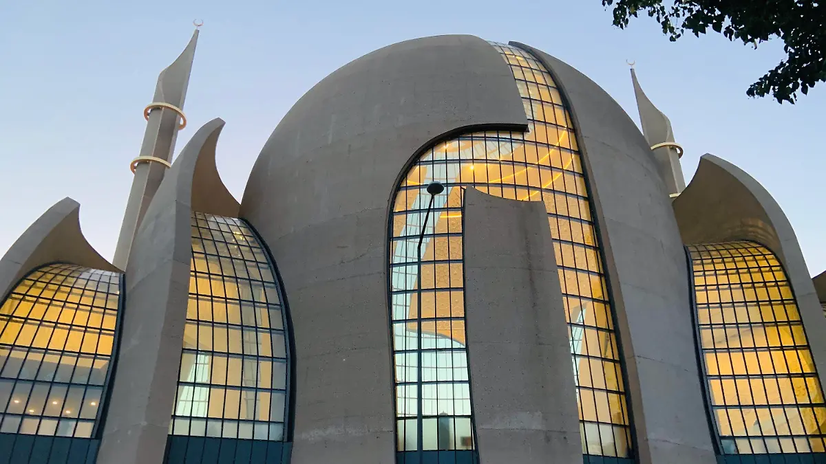ARCHIV - 06.07.2021, Nordrhein-Westfalen, Köln: Die Zentralmoschee in Köln-Ehrenfeld leuchtet in der Abenddämmerung von innen. (zu dpa "Erster Antrag auf Muezzin-Ruf in Köln eingegangen ") Foto: Christoph Driessen/dpa +++ dpa-Bildfunk +++
