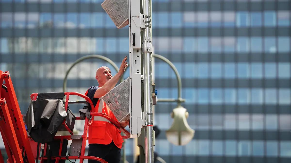 31.05.2023, Berlin: Stephan Rodriguez installiert im Auftrag der Firma Viginoiz auf dem Mittelstreifen des Kurfürstendamms einen sogenannten Lärmblitzer. Der aus Frankreich ausgeliehene Lärmblitzer soll für acht Wochen im Berliner Straßenverkehr im Rahmen eines wissenschaftlichen Forschungsprojektes mit der TU Berlin erprobt werden. Damit können sehr laute Fahrzeuge im Straßenverkehr identifiziert werden. Foto: Soeren Stache/dpa +++ dpa-Bildfunk +++