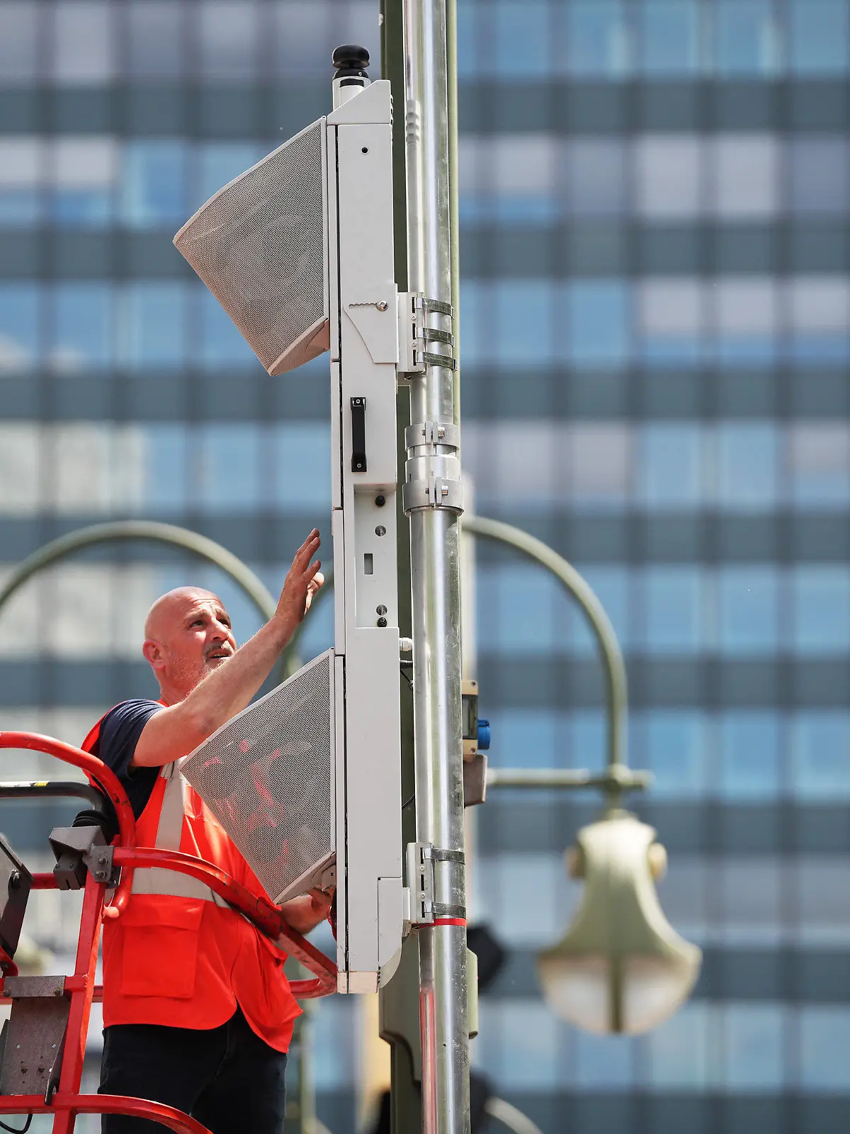 31.05.2023, Berlin: Stephan Rodriguez installiert im Auftrag der Firma Viginoiz auf dem Mittelstreifen des Kurfürstendamms einen sogenannten Lärmblitzer. Der aus Frankreich ausgeliehene Lärmblitzer soll für acht Wochen im Berliner Straßenverkehr im Rahmen eines wissenschaftlichen Forschungsprojektes mit der TU Berlin erprobt werden. Damit können sehr laute Fahrzeuge im Straßenverkehr identifiziert werden. Foto: Soeren Stache/dpa +++ dpa-Bildfunk +++