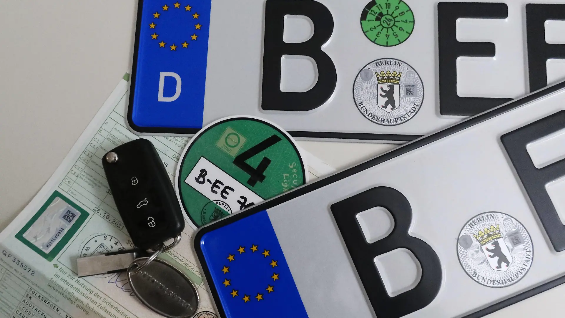 19.01.2023, Berlin, GER - Autokennzeichen, gruene Umweltplakette, Autoschluessel und Zulassungsbescheinigung. Abgasnorm, Anschnitt, Autokennzeichen, Autonummmer, Autoschluessel, Berlin, Besitzernachweise, Buchstaben, Buerokratie, deutsch, Deutschland, Dienstwagen, Dokumente, Draufsicht, Eigentuemernachweise, Eigentum, Eintrag, Europa, europaisch, Fahrzeugpapier, Feinstaubplakette, Halter, Identifikation, Kennzeichen, KFZ-Kennzeichen, KFZ-Papier, KFZ-Zulassung, Legitimation, Lizenz, Neuwagen, Neuzulassung, niemand, Nummernschilder, Papier, Plakette, QF, Querformat, Scheine, Schilder, Schluessel, Stilleben, Stillleben, Studioaufnahme, Symbol, Symbolfoto, Symbolik, symbolisch, TUEV-Plakette, Umweltplakette, Vogelperspektive, Westeuropa, Wirts