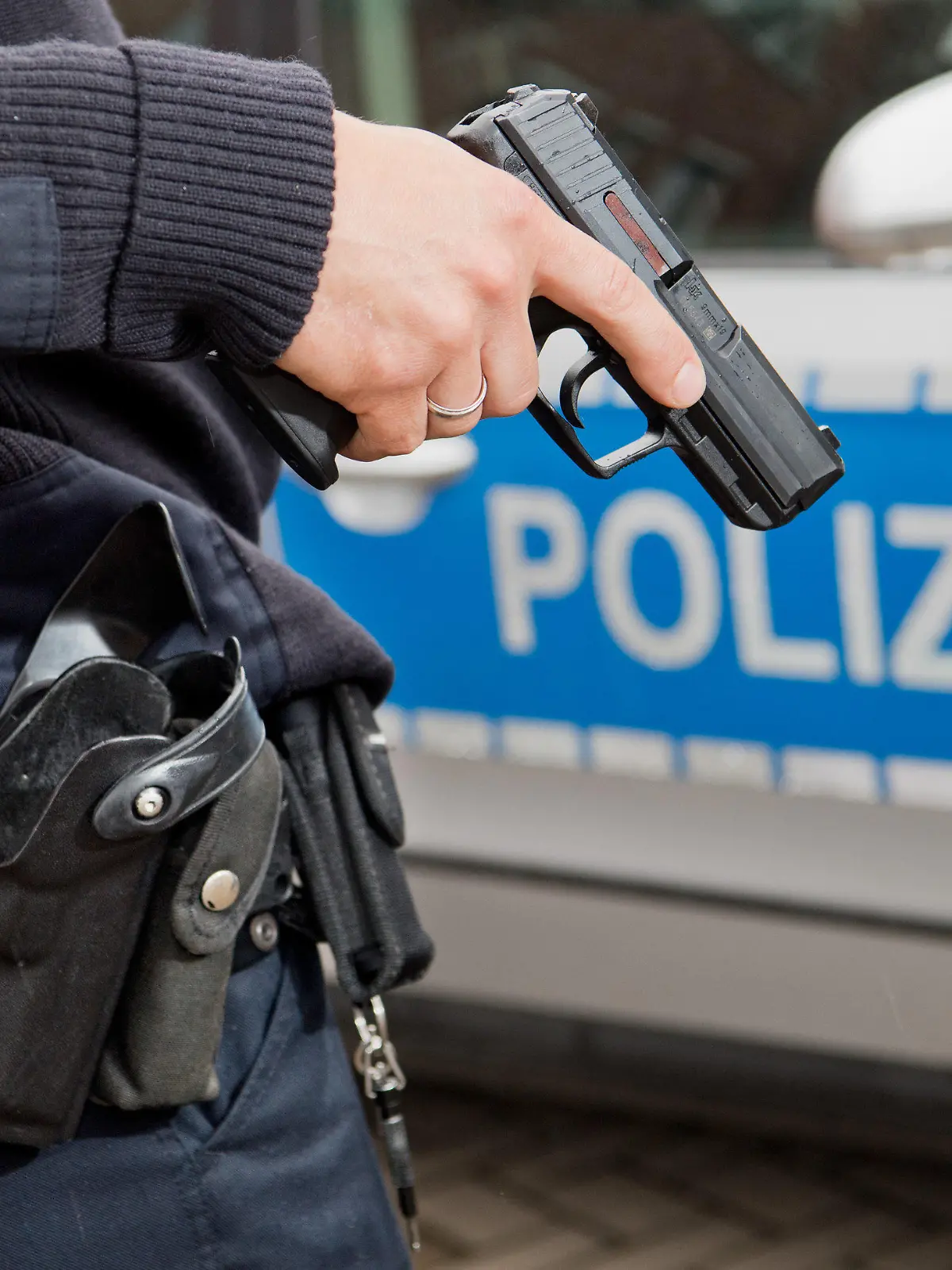 ARCHIV - Ein Polizist posiert am 13.06.2016 für Fotoaufnahmen mit seiner Dienstwaffe HK P2000 9mm vor einem Polizeifahrzeug. Foto: Julian Stratenschulte/dpa (zu dpa «Sachsen rüstet Polizei auf - neue Waffen, neue Ausrüstung» vom 09.08.2016) +++(c) dpa - Bildfunk+++