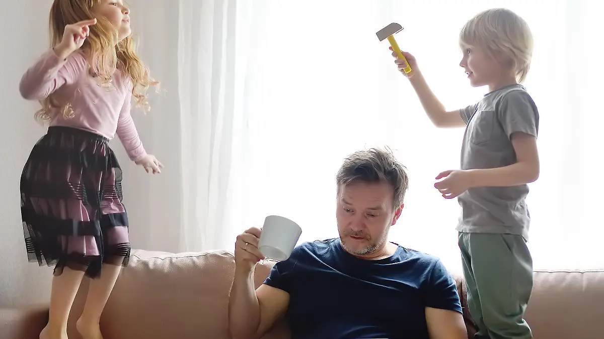 Tired father with his two kids during quarantine. Stay at home concept. Online working and household at the same time while quarantine. Exhausted parents with children.