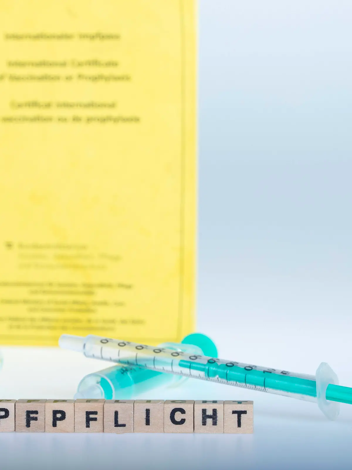  Coronavirus: Impfungen und Impfpass *** Corona virus: Vaccinations and vaccination certificate Aufgrund der Verbreitung des Coronavirus und der neueren und höher ansteckenden Deltavariante wird seitens der Regierung eine hohe Durchimpfungsrate der Bevölkerung angestrebt. Auch wird über eine Impfpflicht für spezielle Berufsgruppen diskutiert. Im Bild: Spritzen und Kanülen liegen mit Buchstabenwürfel ,,Impfpflicht vor gelbem Impfpass. Wien, Österreich. 25.07.2021 *** Due to the spread of the corona virus and the new delta variation the Austrian government focuses a high level of vaccination coverage of the population. Mandatory vaccinations for specific professional groups are discussed. Picture: Injection and letter cubes ,,Impfpflic PUBLICATIONxNOTxINxAUT