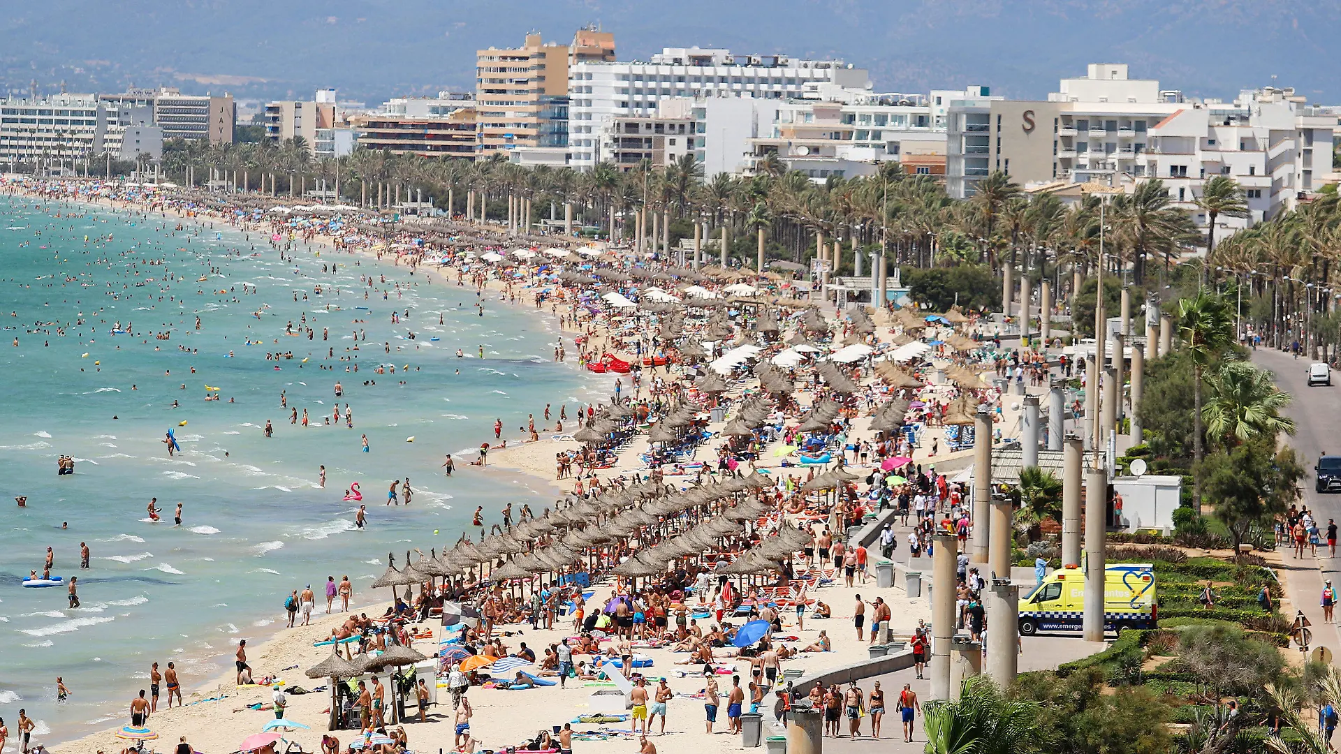 ARCHIV - 12.08.2018, Spanien, Palma: Hotels stehen am Strand von El Arenal, an dem zahlreiche Touristen die Sonne genießen. Mit Schnäppchenpreisen und Rabatten von bis zu 50 Prozent werben Veranstalter um Kurzentschlossene. (zu dpa: "Gute Zeiten für Schnäppchenjäger - Reisebranche setzt auf Last-Minute") Foto: Clara Margais/dpa +++ dpa-Bildfunk +++