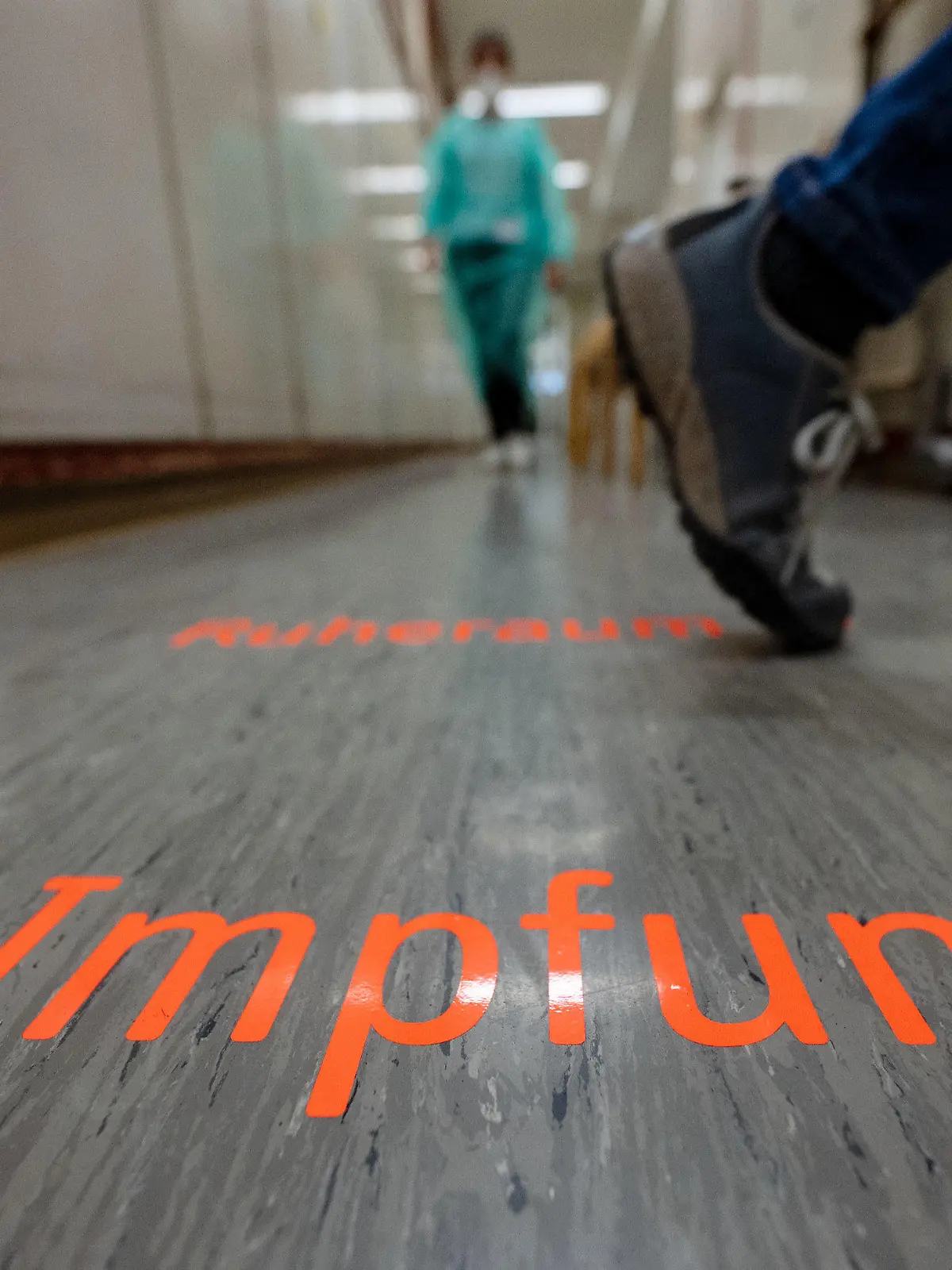 16.11.2021, Baden-Württemberg, Tübingen: Das Wort ·Impfung· steht auf dem Boden der alten Universitäts-Apotheke. Das Mobile Impfteam Tübingen bietet im alten Gebäude der früheren Uniapotheke Impfungen mit vorheriger Online-Terminvereinbarung an. Foto: Marijan Murat/dpa +++ dpa-Bildfunk +++
