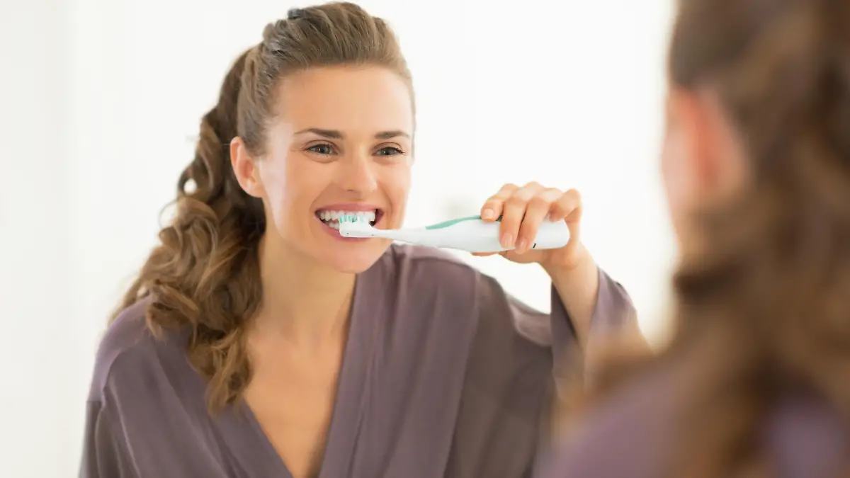 Young woman brushing teeth in bathroom