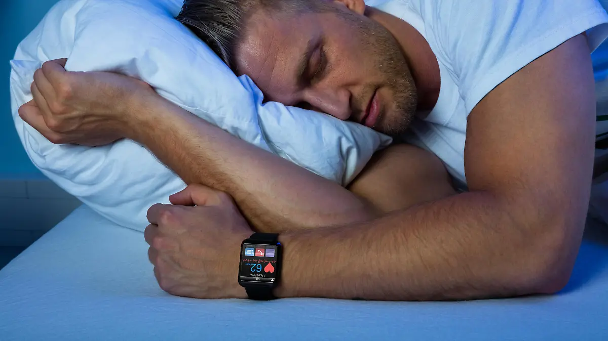 Man Sleeping With Smart Watch In His Hand Showing Heartbeat Rate