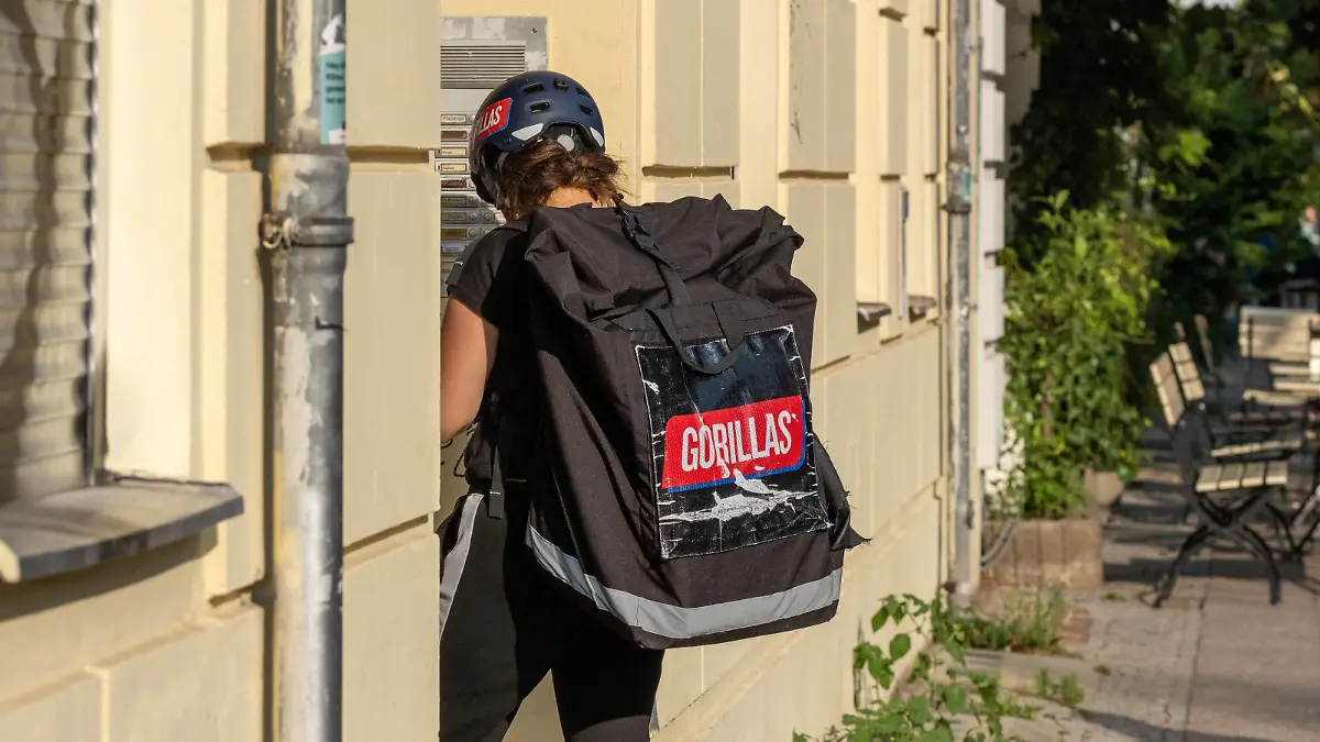  Mitarbeiter des Gorillas-Lieferdiestes an der Haustür bei der Auslieferung von Waren in Berlin. / Gorilla delivery service employees at the front door delivering goods in Berlin. Gorillas-Lieferdienst *** Gorillas delivery service employees at the front door delivering goods in Berlin Gorilla delivery service employees at the front door delivering goods in Berlin Gorillas delivery service