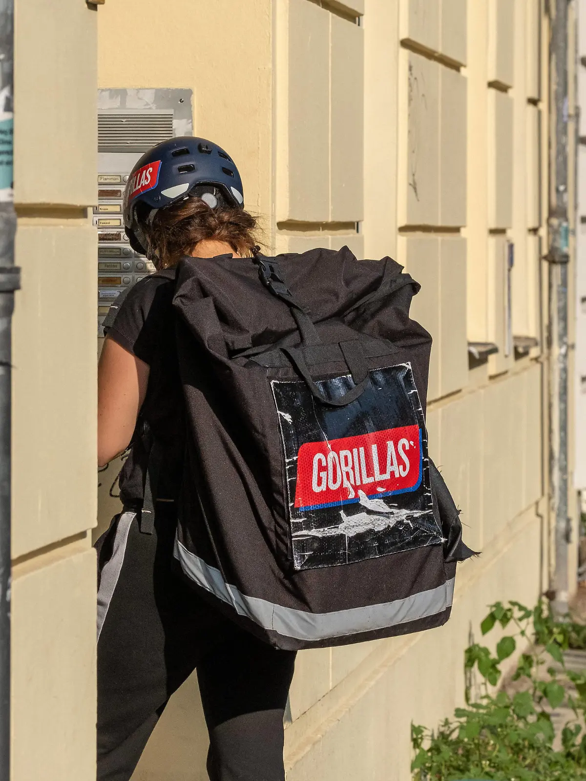  Mitarbeiter des Gorillas-Lieferdiestes an der Haustür bei der Auslieferung von Waren in Berlin. / Gorilla delivery service employees at the front door delivering goods in Berlin. Gorillas-Lieferdienst *** Gorillas delivery service employees at the front door delivering goods in Berlin Gorilla delivery service employees at the front door delivering goods in Berlin Gorillas delivery service