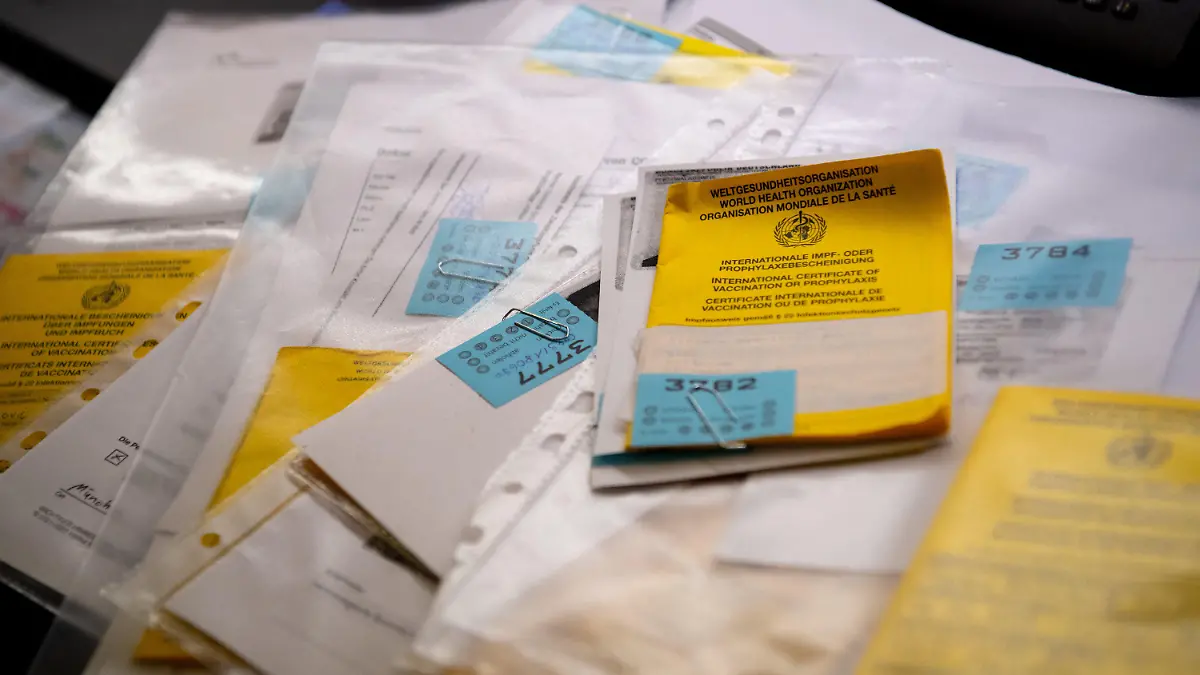 ARCHIV - 14.06.2021, München: Zahlreiche Impfpässe liegen in einer Apotheke in einem Büro auf einem Tisch. (zu: "150 Euro für Impfpass-Fälschung - Polizei ermittelt in vielen Fällen") Foto: Sven Hoppe/dpa +++ dpa-Bildfunk +++