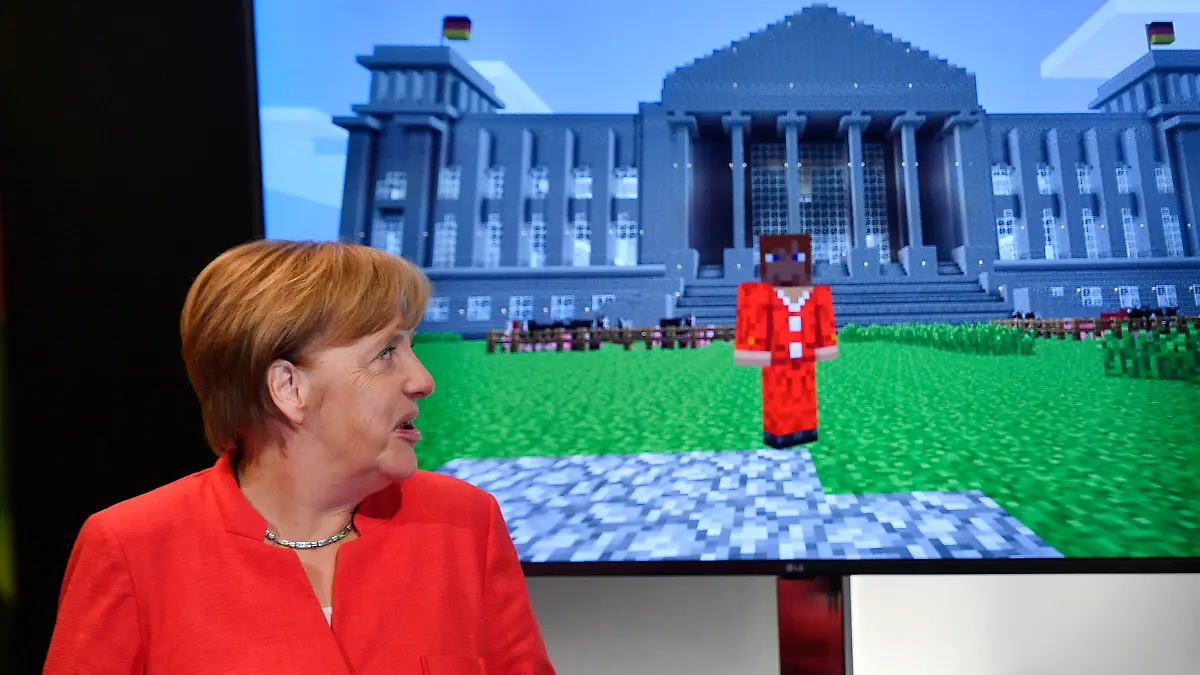 German chancellor Angela Merkel standing beside a Minecraft game, showing her in front of the German Reichstag, during the Gamescom fair for computer games in Cologne, Germany, Tuesday, Aug. 22, 2017. The leading European trade fair for digital gaming culture is the meeting point for global companies from the entertainment industry and the international gaming community. (AP Photo/Martin Meissner)