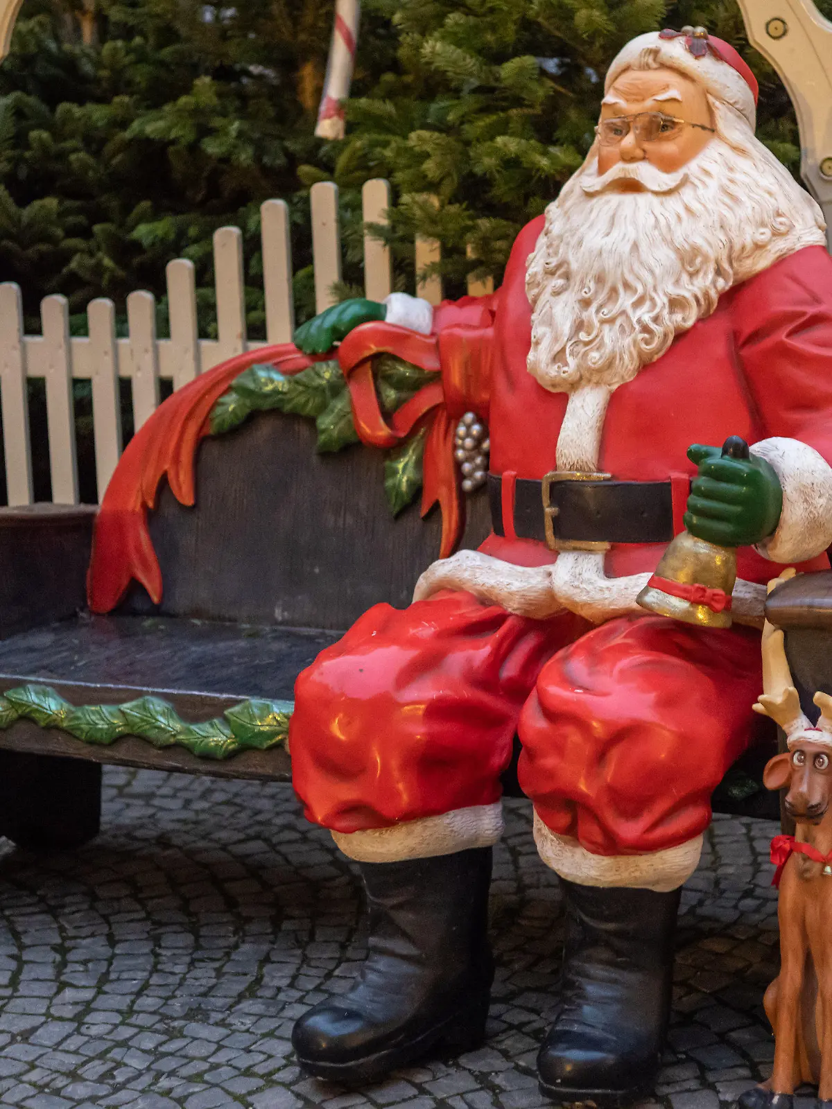 16.11.2021, Bayern, München: Eine Weihnachstmann-Kunststofffigur auf einer Sitzbank steht auf dem Gelände des  Weihnachtsmarktes in den Innenhöfen der Residenz, für den bereits die Aufbauarbeiten begannen. Der traditionelle Christkindlmarkt allerdings wurde wegen der hohen Zahl an Corona-Infizierten von der Stadt München  am 16.11. abgesagt Foto: Peter Kneffel/dpa +++ dpa-Bildfunk +++