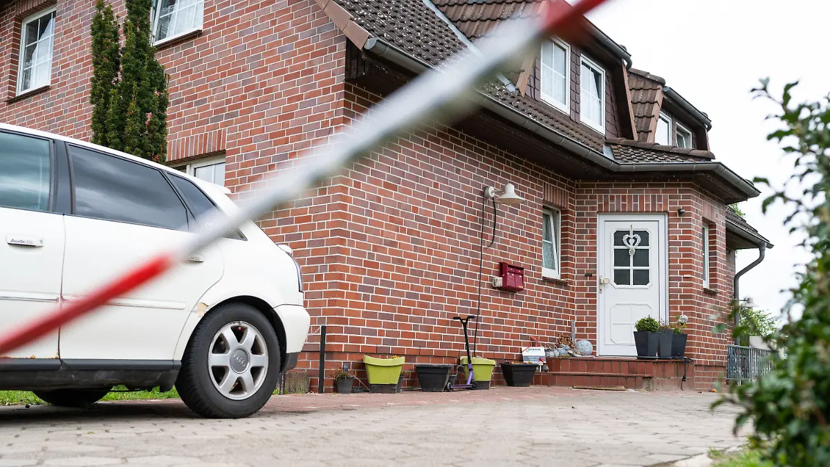 ARCHIV - 18.05.2021, Niedersachsen, Bispingen: Absperrband der Polizei hängt vor einem Wohnhaus. Eine Frau und ihr vierjähriger Sohn wurden am 16.05.2021 tot in dem Haus entdeckt, die Leiche ihrer elfjährigen Tochter später in einem Waldstück gefunden. (Zu dpa: «Mordprozess gegen 35-Jährigen nach Tod von Mutter und Kindern») Foto: Philipp Schulze/dpa +++ dpa-Bildfunk +++