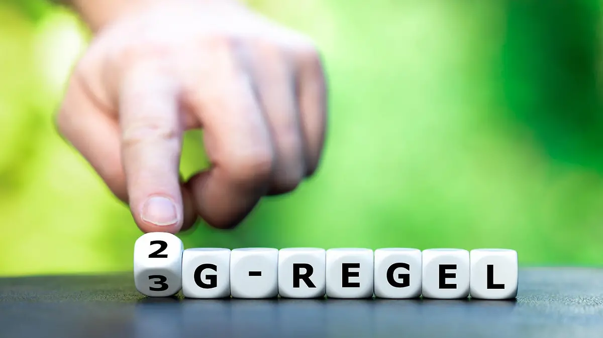 Symbol for the regulation that only vaccinated and recovered people have access to certain events. Hand is turning a dice and changes the expression "3G-Regel" (3G-rule) to "2G-Regel"(2G-rule)