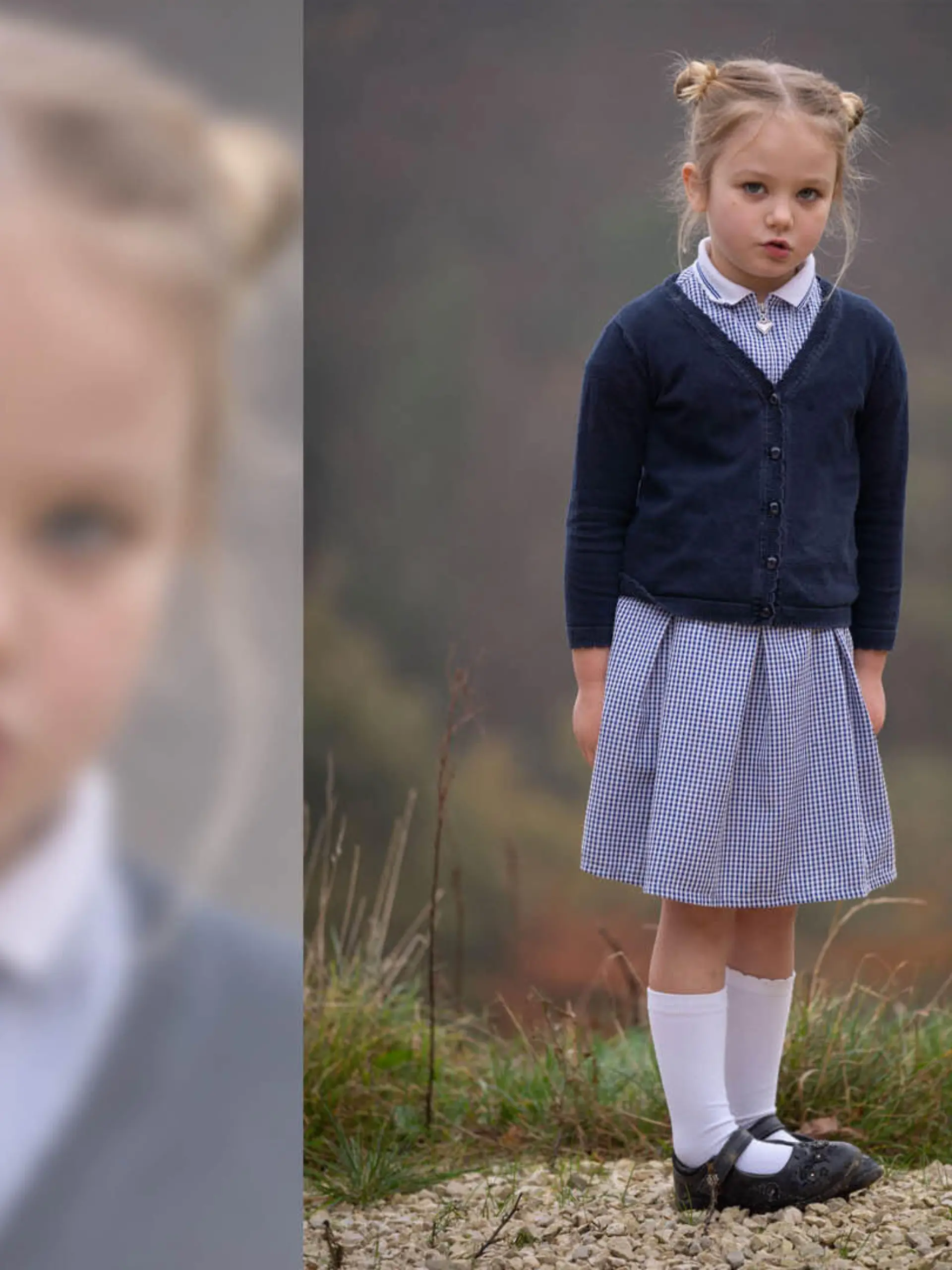 Die zierliche fünfjährige Lily steht in einem blauen Kleid vor der Kamera.