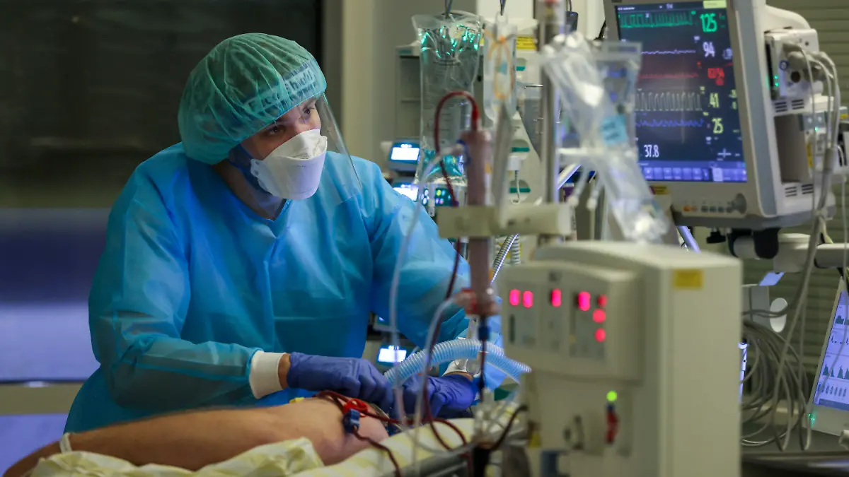 15.11.2021, Sachsen, Leipzig: Ein Intensivpfleger versorgt einen Covid-19-Patienten auf der Intensivstation der Leipziger Uniklinik. ·Aufgrund der steigenden Corona-Infektionszahlen und der damit stark gestiegene Zahl behandlungsbedürftiger Covid-19-Patienten hat das Universitätsklinikum die Zahl der geplanten Operationen um über 30 Prozent verringert. Damit sollen die Kapazitäten für die Behandlung der Corona-Patienten gesichert werden. Foto: Jan Woitas/dpa-Zentralbild/dpa +++ dpa-Bildfunk +++