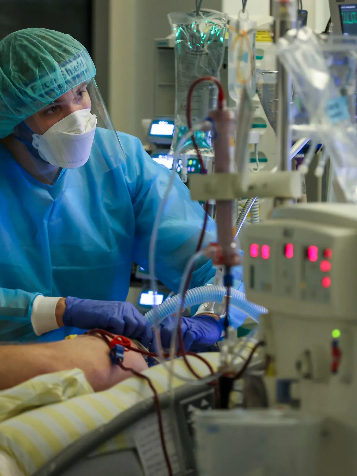 15.11.2021, Sachsen, Leipzig: Ein Intensivpfleger versorgt einen Covid-19-Patienten auf der Intensivstation der Leipziger Uniklinik. ·Aufgrund der steigenden Corona-Infektionszahlen und der damit stark gestiegene Zahl behandlungsbedürftiger Covid-19-Patienten hat das Universitätsklinikum die Zahl der geplanten Operationen um über 30 Prozent verringert. Damit sollen die Kapazitäten für die Behandlung der Corona-Patienten gesichert werden. Foto: Jan Woitas/dpa-Zentralbild/dpa +++ dpa-Bildfunk +++