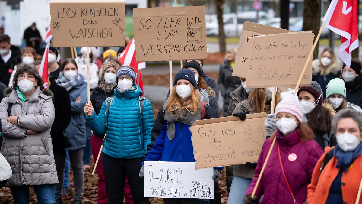 Beschäftigte im Gesundheitswesen nehmen vor dem Klinikum in Großhadern an einem Warnstreik teil und halten dabei ein Plakat mit der Aufschrift «Erst Klatschen am Balkon - dann Klatsche ins Gesicht» hoch. In der laufende Tarifrunde fordert Verdi fünf Prozent mehr Gehalt, mindestens aber 150 Euro monatlich. Im Gesundheitswesen werden 300 Euro im Monat mehr verlangt.