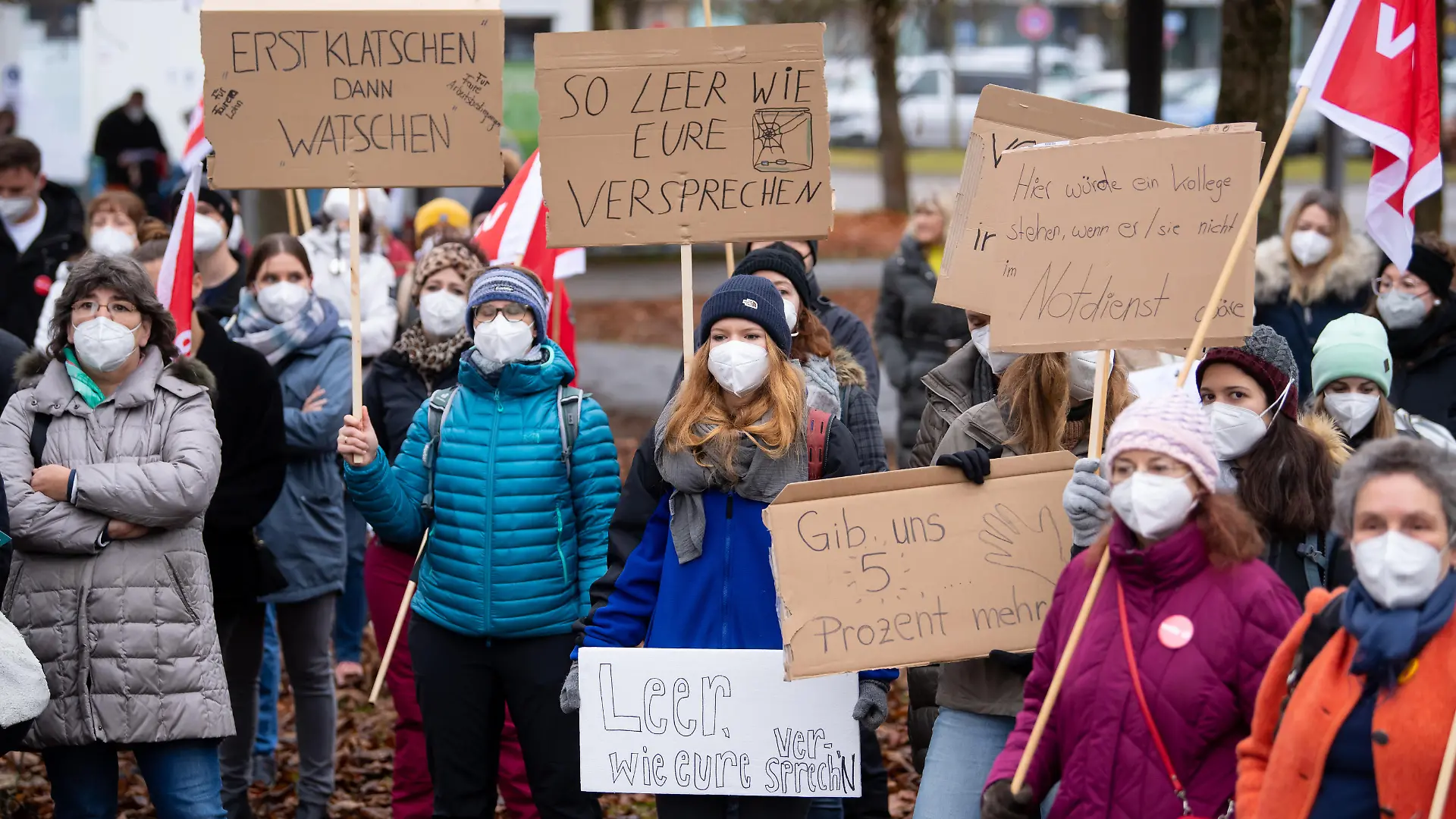 Beschäftigte im Gesundheitswesen nehmen vor dem Klinikum in Großhadern an einem Warnstreik teil und halten dabei ein Plakat mit der Aufschrift «Erst Klatschen am Balkon - dann Klatsche ins Gesicht» hoch. In der laufende Tarifrunde fordert Verdi fünf Prozent mehr Gehalt, mindestens aber 150 Euro monatlich. Im Gesundheitswesen werden 300 Euro im Monat mehr verlangt.