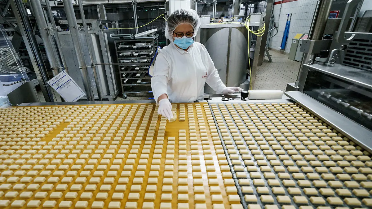 03.11.2021, Schleswig-Holstein, Lübeck: Eine Arbeiterin kontrolliert in einer Produktionsanlage der Firma Niederegger die Form von Marzipanstücken. Bei Niederegger ist die Weihnachtsproduktion in vollem Gang. Foto: Axel Heimken/dpa +++ dpa-Bildfunk +++